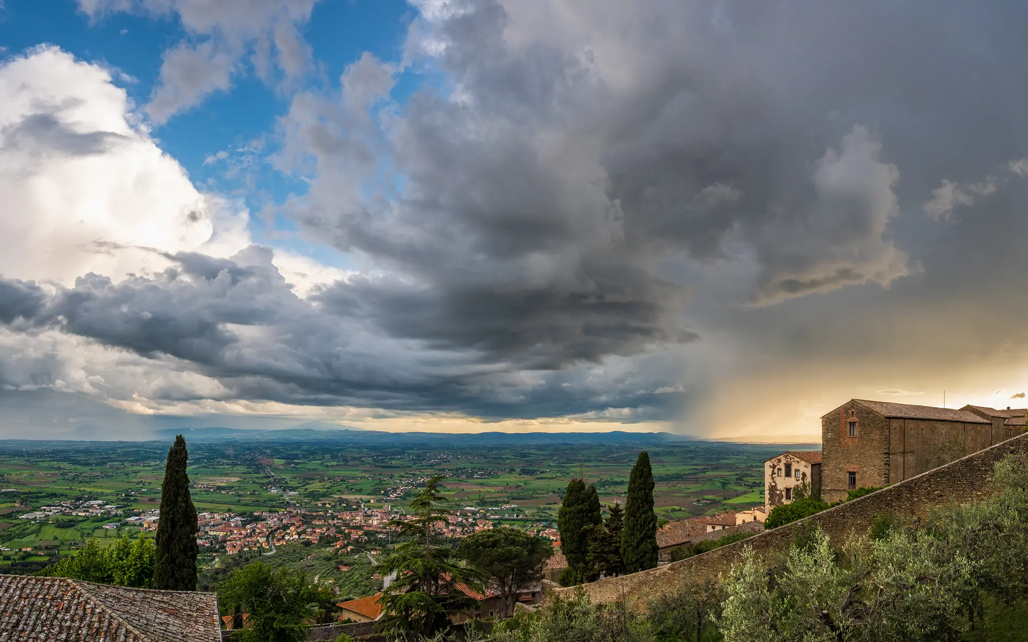 A thunderstorm approaches Cortona during sunset on May 11, 2023