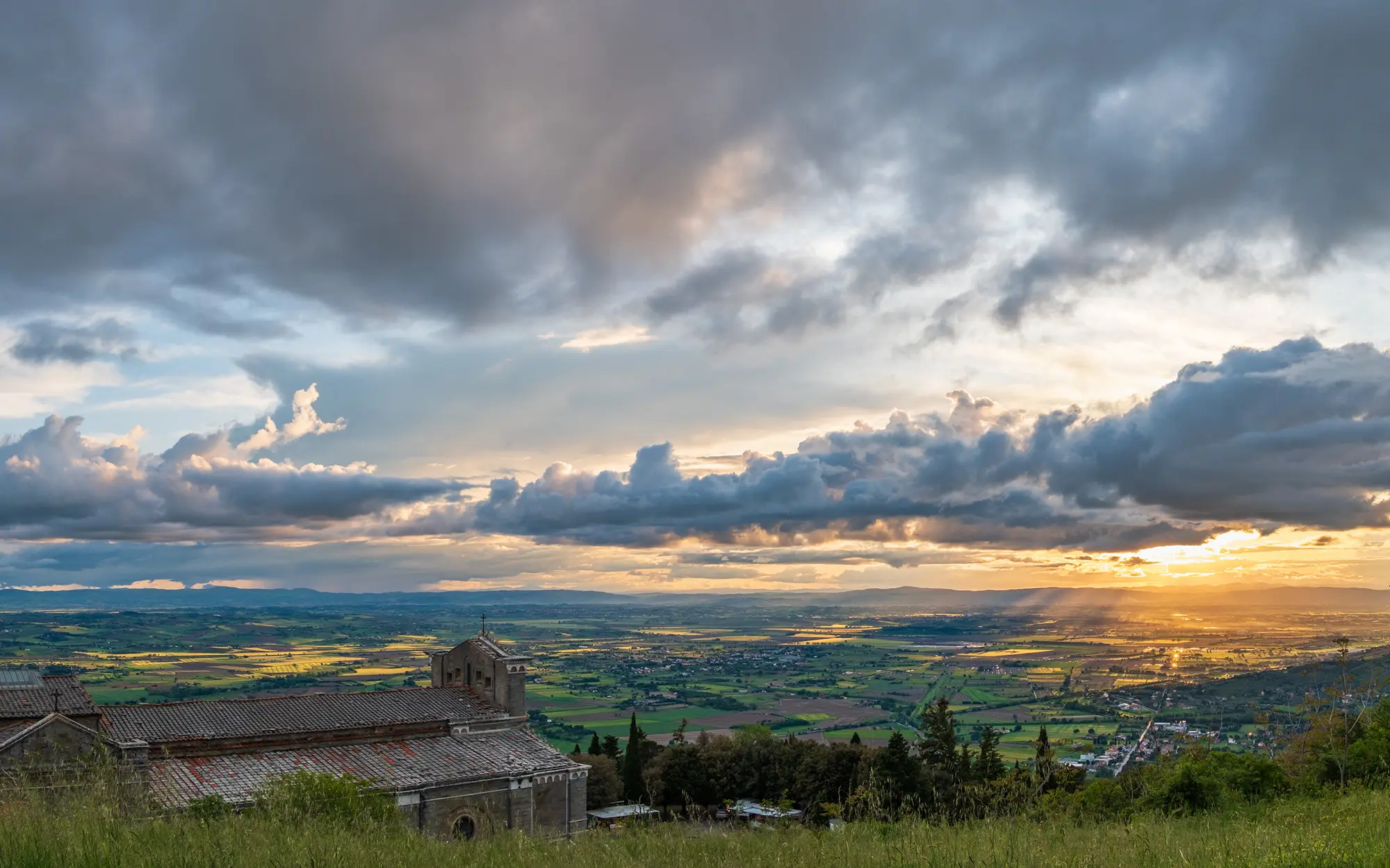 Sundown over the valley, as seen from above Basilica di Santa Margherita in Cortona on May 14, 2023.