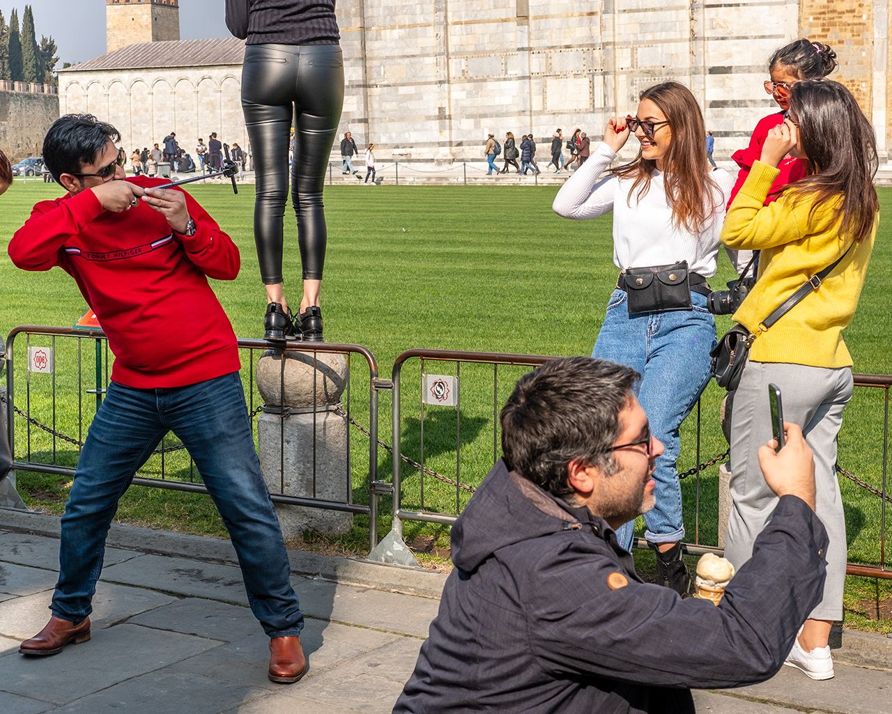 Visitors pose in front of the Campanile (the Leaning Tower) in Pisa, Italia.