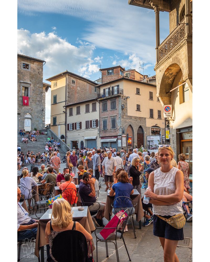 Ferragosto holiday crowd in Piazza della Repubblica in Cortona, Italia.