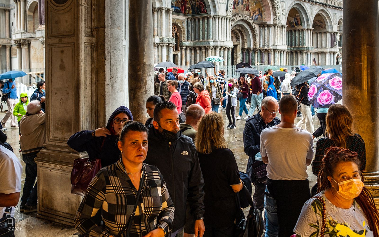 Visitors in Piazza San Marco on a rainy day in Venezia, Italia.