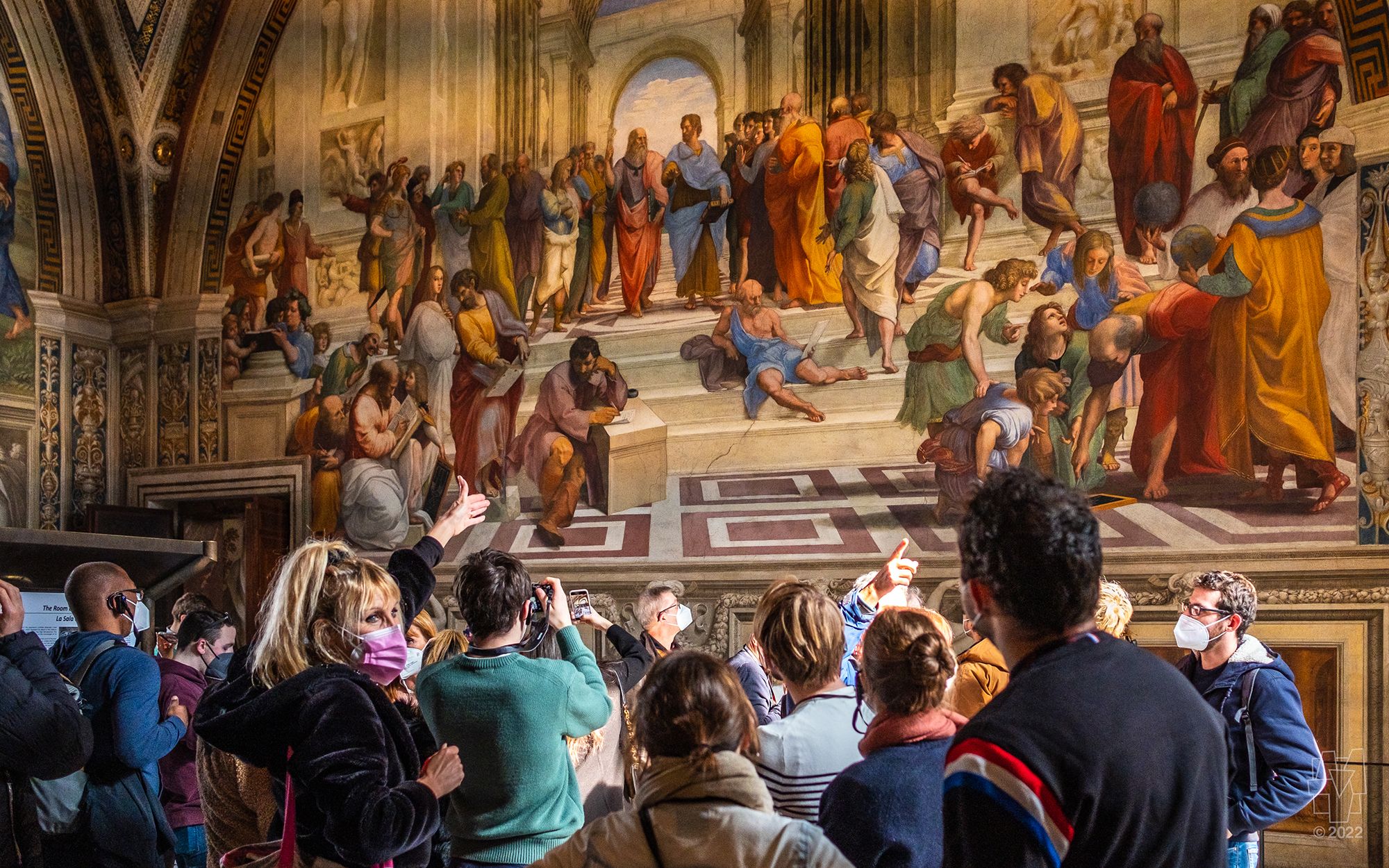 A tour guide shows visitors to the Vatican Museums Raphael's _School of Athens_ fresco. 
